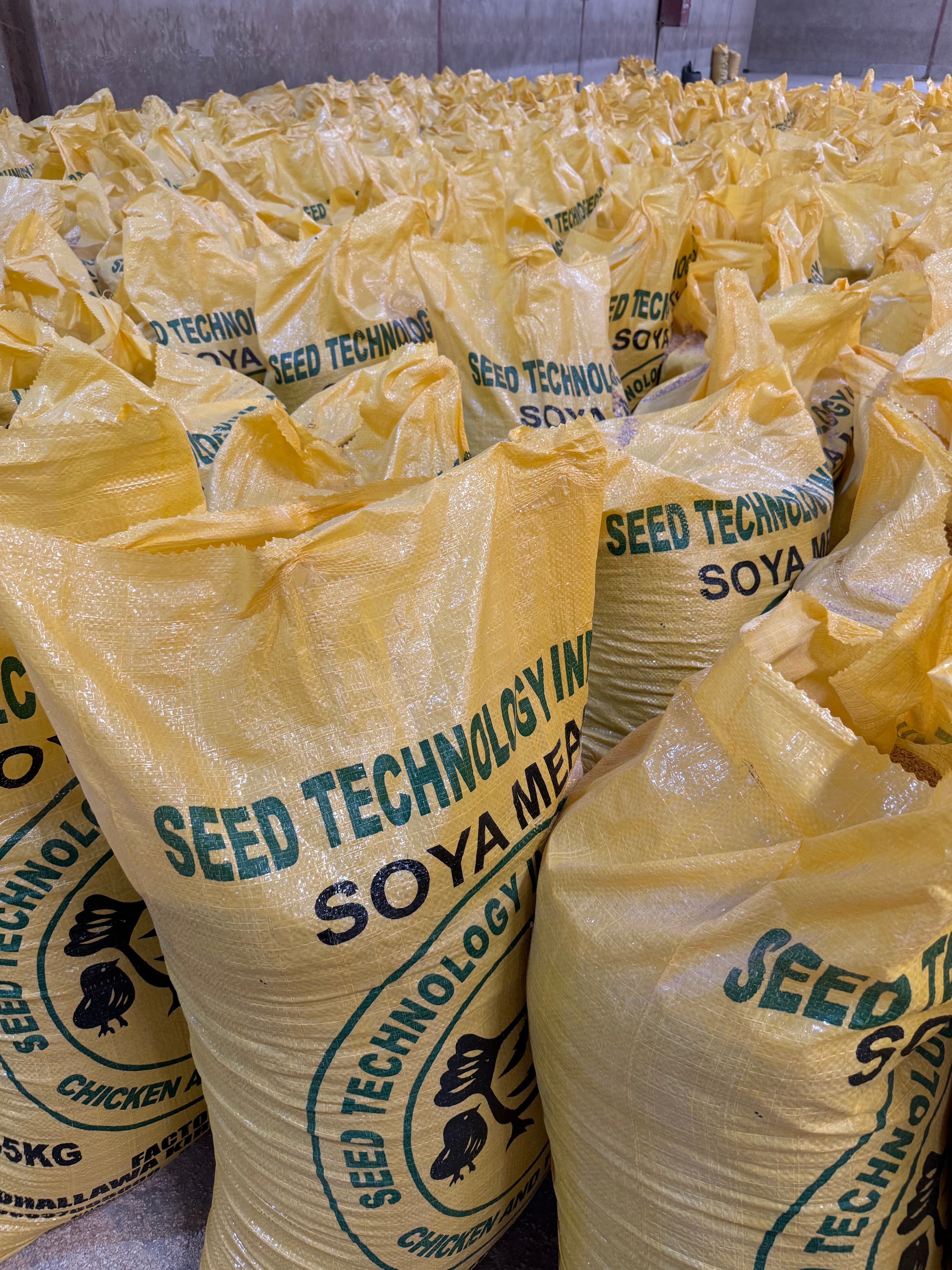 Stacked yellow sacks of Seed Technology soya meal